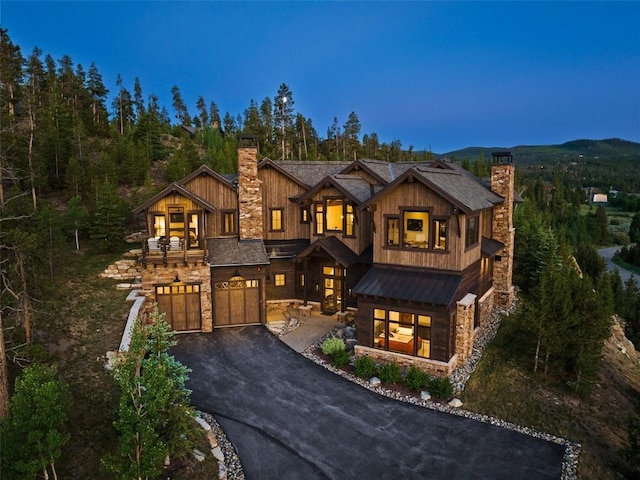 455 Highfield Trl, Breckenridge, CO 80424 - view of front of home featuring a chimney, stone siding, driveway, and a garage