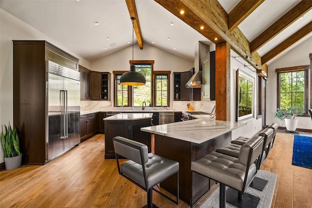 455 Highfield Trl, Breckenridge, CO 80424 - kitchen with stainless steel built in fridge, beamed ceiling, light wood finished floors, light stone countertops, and dark brown cabinets