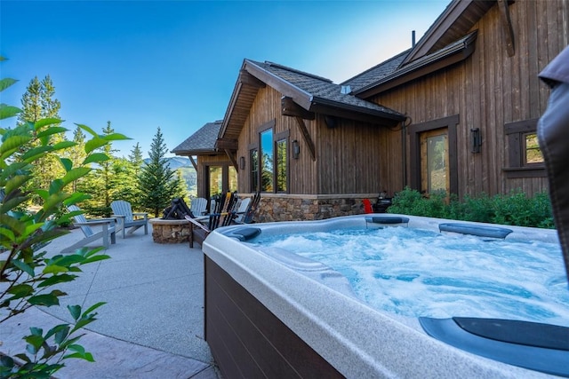 455 Highfield Trl, Breckenridge, CO 80424 - view of property exterior with a hot tub, an outdoor fire pit, a shingled roof, and a patio area