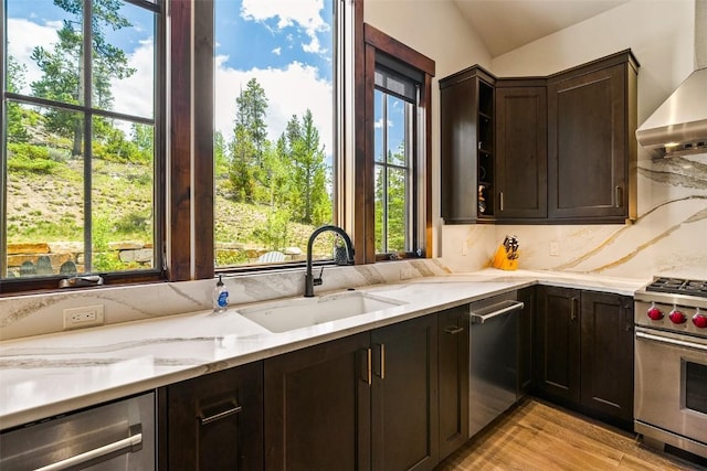 455 Highfield Trl, Breckenridge, CO 80424 - kitchen featuring stainless steel appliances, wall chimney range hood, dark brown cabinets, healthy amount of natural light, and lofted ceiling