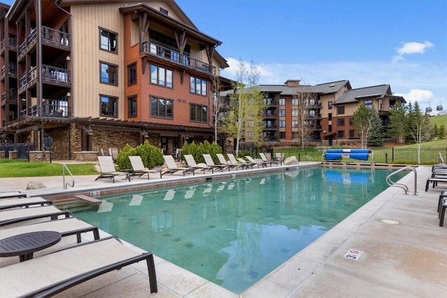community pool featuring a patio and fence
