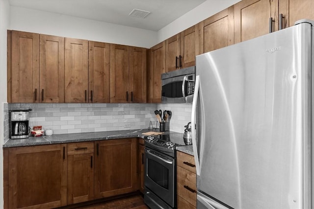 kitchen with decorative backsplash, brown cabinetry, visible vents, dark wood finished floors, and stainless steel appliances