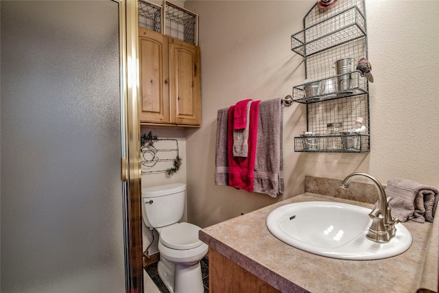 bathroom with a stall shower, vanity, and toilet