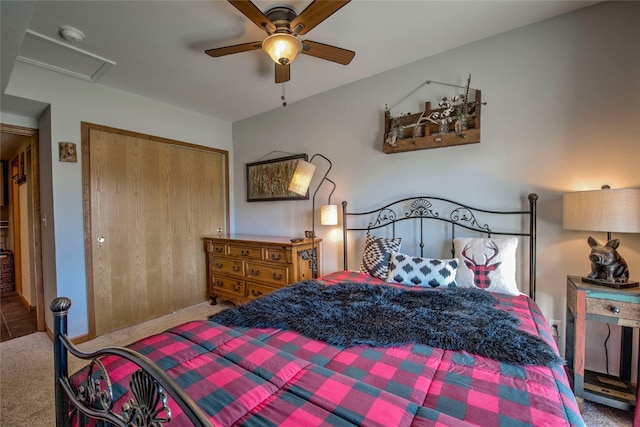 carpeted bedroom featuring attic access, a closet, and ceiling fan