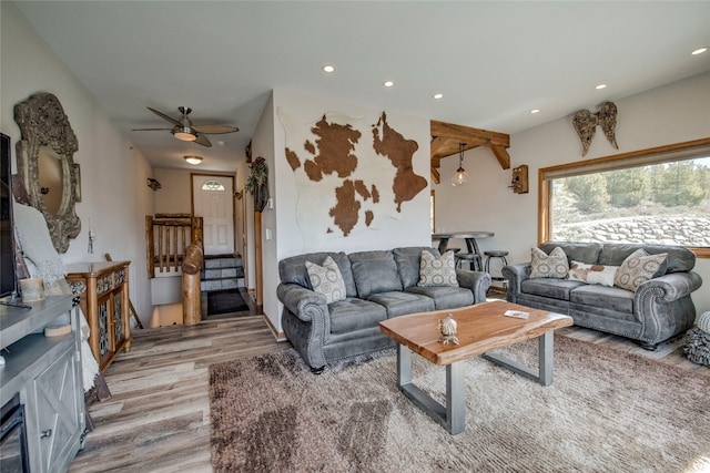 living room featuring recessed lighting, light wood finished floors, stairs, and a ceiling fan