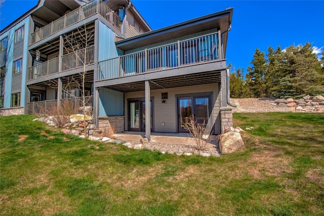 rear view of property with a yard and a patio