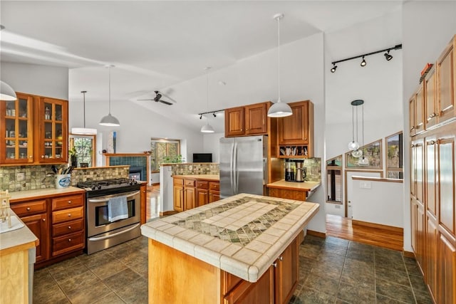 663 Amethyst Dr, Steamboat Springs, CO 80487 - kitchen with stainless steel appliances, rail lighting, tasteful backsplash, lofted ceiling, and a kitchen island