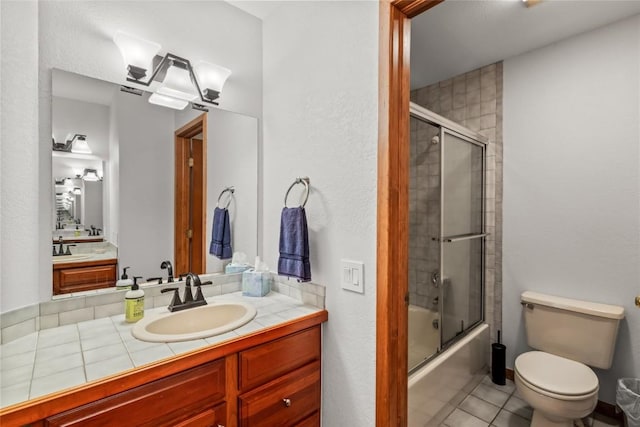 663 Amethyst Dr, Steamboat Springs, CO 80487 - full bathroom with toilet, combined bath / shower with glass door, vanity, and tile patterned floors