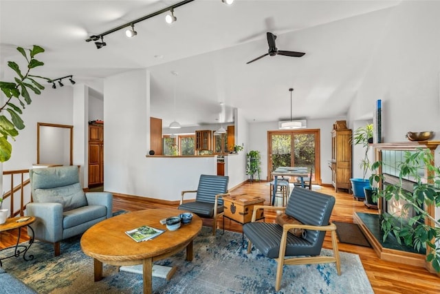 663 Amethyst Dr, Steamboat Springs, CO 80487 - living area with light wood-type flooring, vaulted ceiling, track lighting, a ceiling fan, and baseboards