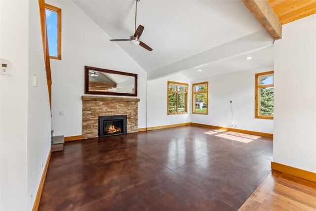 475 Vail Cir, Dillon, CO 80435 - unfurnished living room with baseboards, beam ceiling, a stone fireplace, a ceiling fan, and concrete flooring