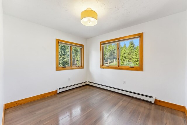 475 Vail Cir, Dillon, CO 80435 - empty room featuring wood finished floors, baseboards, and a baseboard heating unit