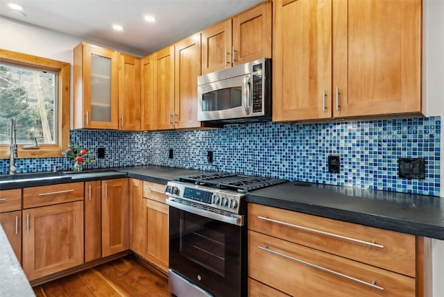 475 Vail Cir, Dillon, CO 80435 - kitchen with stainless steel appliances, dark wood finished floors, dark countertops, glass insert cabinets, and tasteful backsplash