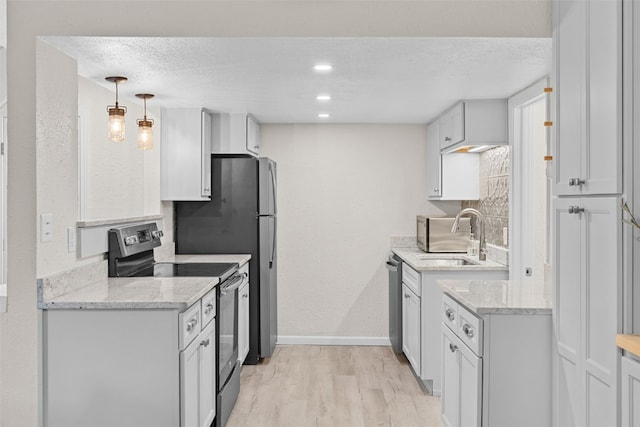 921 Fairview Blvd Unit 14, Breckenridge, CO 80424 - kitchen with appliances with stainless steel finishes, light wood-style flooring, light stone countertops, a textured ceiling, and white cabinetry