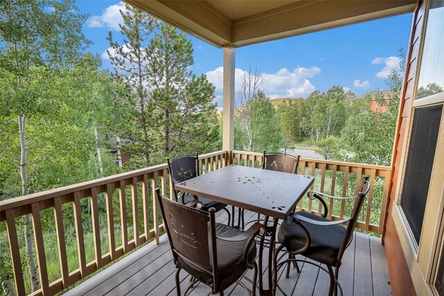 104 Saddle Horn Ct, Granby, CO 80446 - wooden deck featuring a forest view and outdoor dining space