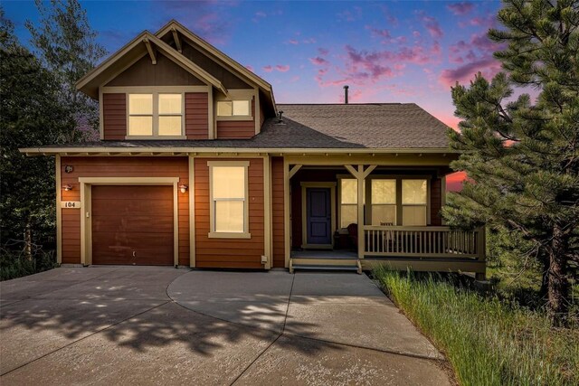 104 Saddle Horn Ct, Granby, CO 80446 - view of front of home featuring concrete driveway, an attached garage, a shingled roof, and covered porch
