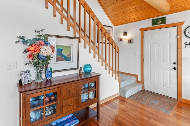 entrance foyer featuring stairs, wood ceiling, baseboards, and wood finished floors