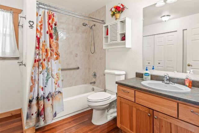 bathroom featuring vanity, toilet, shower / bathtub combination with curtain, and wood finished floors