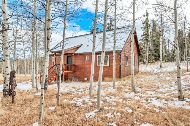 snow covered property featuring a shingled roof