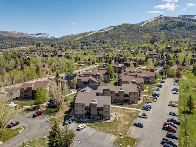 aerial view of property's location featuring a mountainous background and nearby suburban area