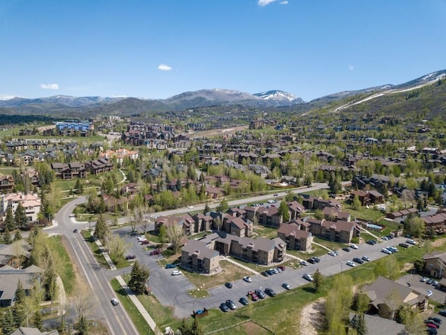 aerial view of property's location featuring a mountain backdrop and nearby suburban area