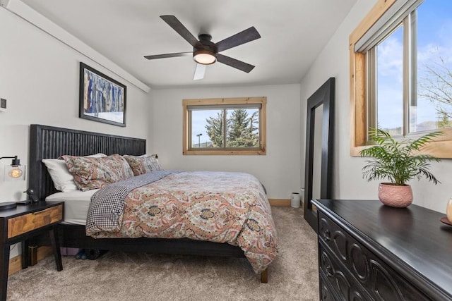 bedroom featuring light carpet, a ceiling fan, and baseboards