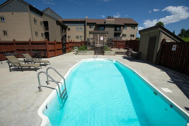 community pool with a patio and fence