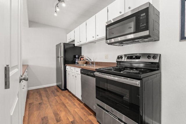 3 Cedar Ct Unit 3, Steamboat Springs, CO 80487 - kitchen featuring appliances with stainless steel finishes, a sink, white cabinets, dark wood finished floors, and baseboards