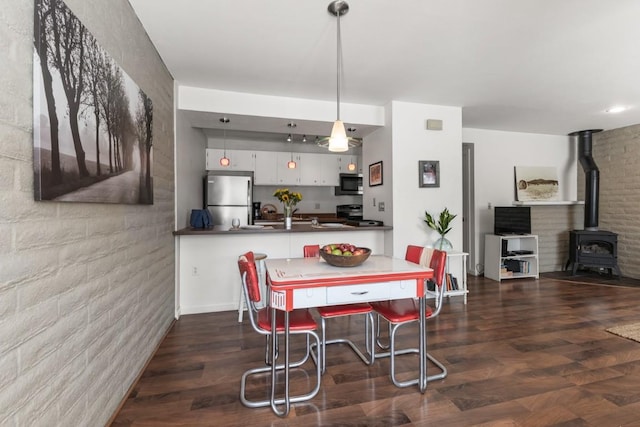 3 Cedar Ct Unit 3, Steamboat Springs, CO 80487 - dining space with a wood stove and dark wood-type flooring