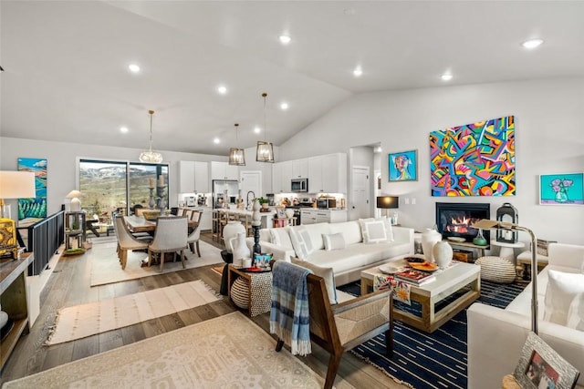 23430 Postrider Trl, Oak Creek, CO 80467 - living room with light wood-type flooring, a glass covered fireplace, recessed lighting, and high vaulted ceiling