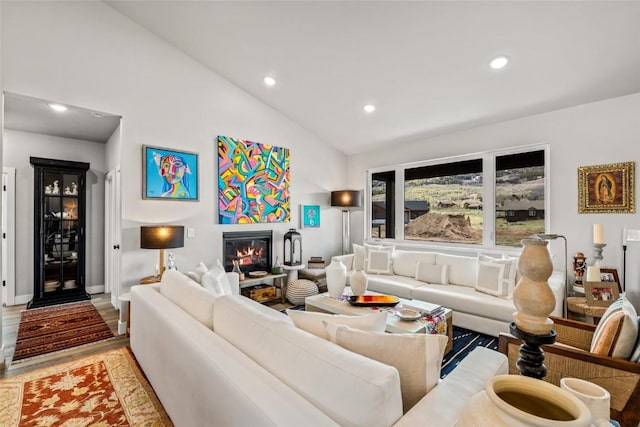23430 Postrider Trl, Oak Creek, CO 80467 - living area featuring recessed lighting, lofted ceiling, a glass covered fireplace, light wood-style floors, and baseboards