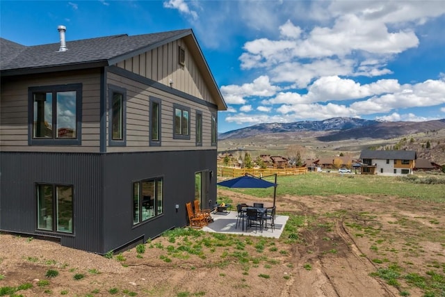 23430 Postrider Trl, Oak Creek, CO 80467 - back of property with a mountain view, a patio area, and a shingled roof