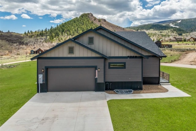23430 Postrider Trl, Oak Creek, CO 80467 - craftsman inspired home featuring a mountain view, a front yard, concrete driveway, an attached garage, and board and batten siding