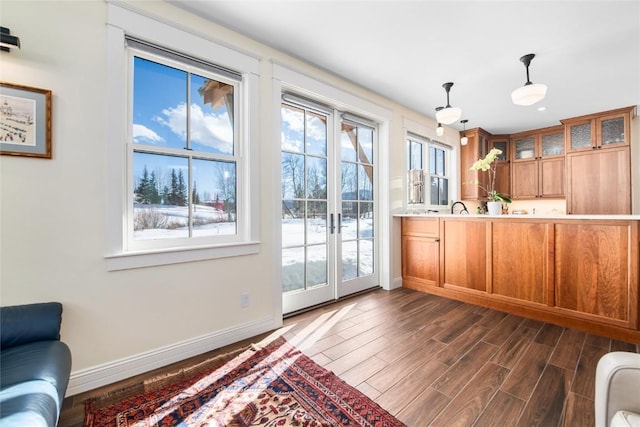 25640 6th Ave, Hahns Peak, CO 80428 - kitchen featuring brown cabinetry, glass insert cabinets, pendant lighting, baseboards, and dark wood-style floors