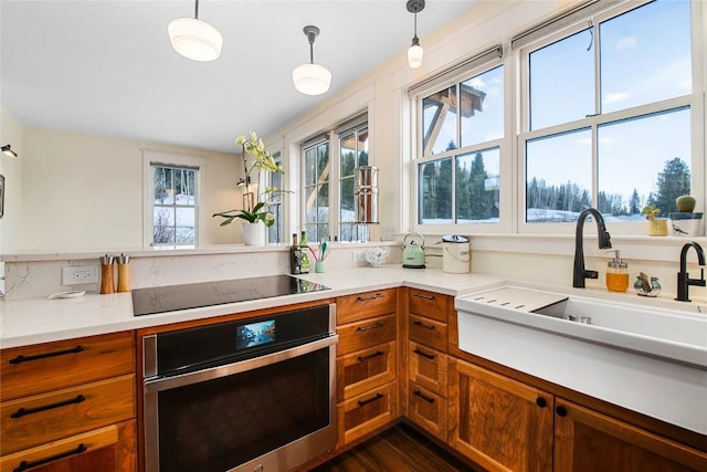 25640 6th Ave, Hahns Peak, CO 80428 - kitchen with a sink, stainless steel oven, brown cabinets, black electric stovetop, and light countertops