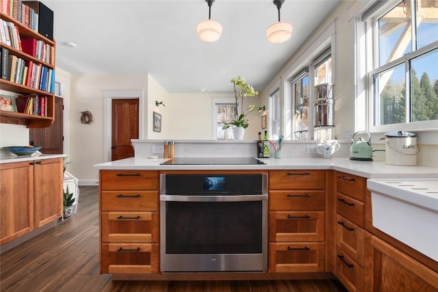 25640 6th Ave, Hahns Peak, CO 80428 - kitchen with dark wood finished floors, oven, light countertops, black electric stovetop, and brown cabinetry