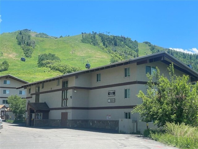 2235 Storm Meadows Dr Unit 322, Steamboat Springs, CO 80487 - kitchen with a textured ceiling, light tile patterned floors, a fireplace, a peninsula, and light stone countertops