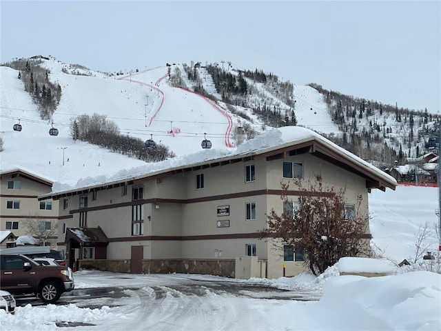 snow covered property featuring stucco siding