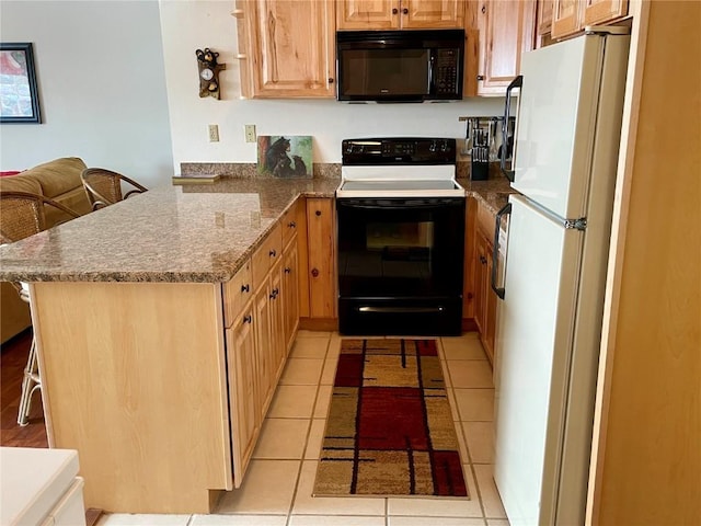 kitchen with a peninsula, electric range, freestanding refrigerator, stone countertops, and black microwave
