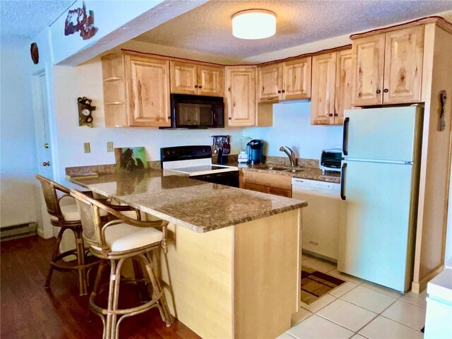 2235 Storm Meadows Dr Unit 322, Steamboat Springs, CO 80487 - kitchen featuring a sink, white appliances, dark stone counters, a peninsula, and a textured ceiling