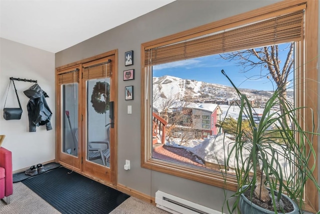 entryway featuring a baseboard radiator, a mountain view, carpet flooring, and baseboards