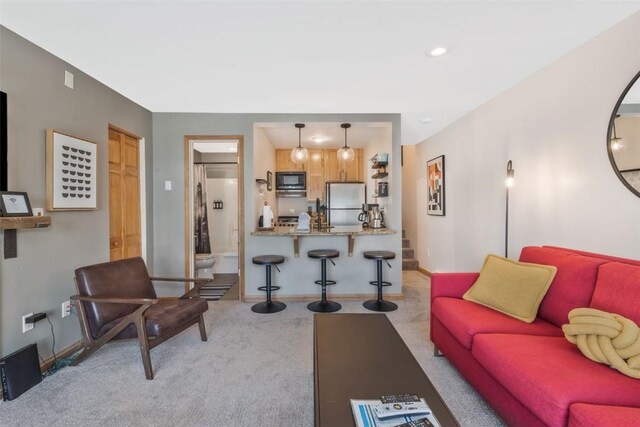 carpeted living area featuring baseboards