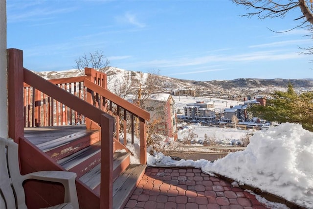 snow covered deck with stairs and a mountain view