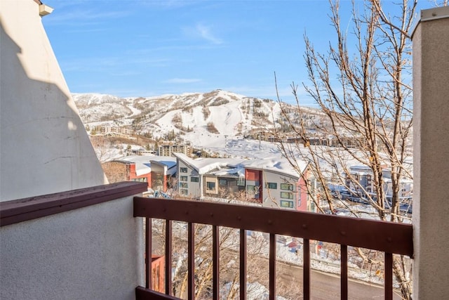 snow covered back of property with a mountain view