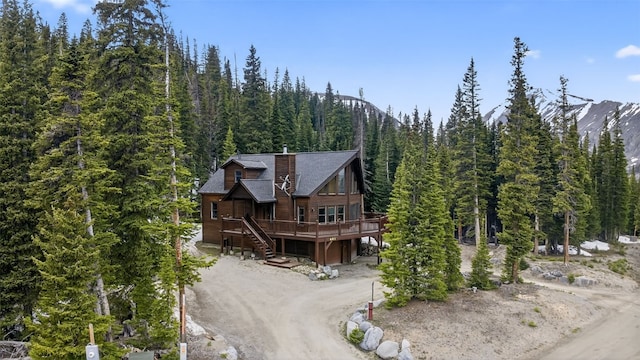 441 Kimmes Ln, Breckenridge, CO 80424 - view of front of house featuring a forest view, driveway, a deck, stairway, and roof with shingles