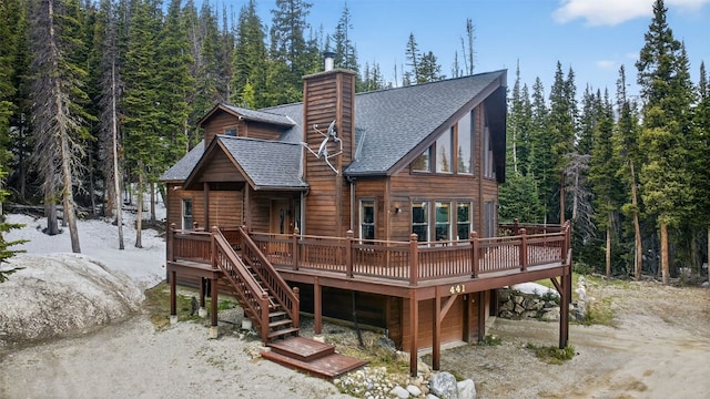 441 Kimmes Ln, Breckenridge, CO 80424 - back of house with roof with shingles, a deck, a chimney, a garage, and a wooded view