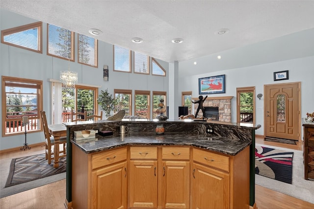 441 Kimmes Ln, Breckenridge, CO 80424 - kitchen featuring high vaulted ceiling, light wood finished floors, dark stone countertops, a center island, and a chandelier