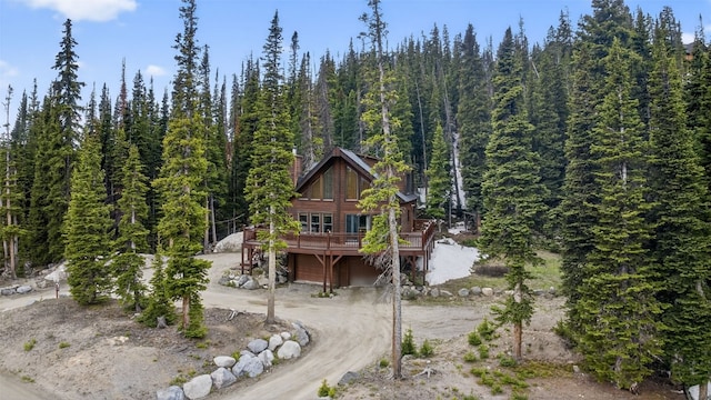 441 Kimmes Ln, Breckenridge, CO 80424 - view of front of house featuring driveway, a view of trees, a deck, and a chimney