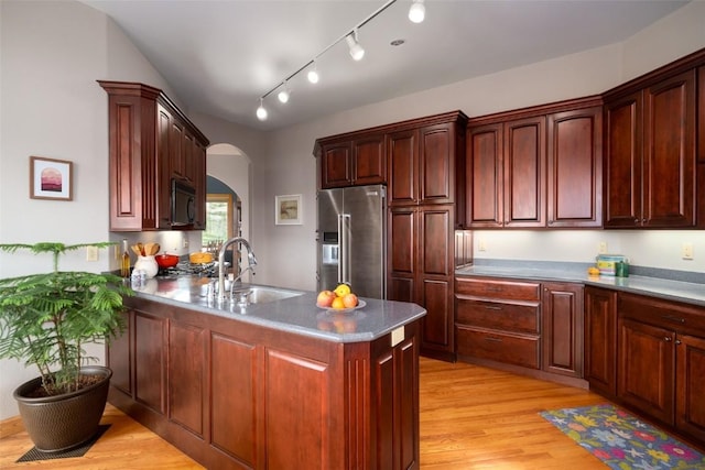43855 Old Elk Trl, Steamboat Springs, CO 80487 - kitchen with high end refrigerator, black microwave, arched walkways, a sink, and light wood-style flooring
