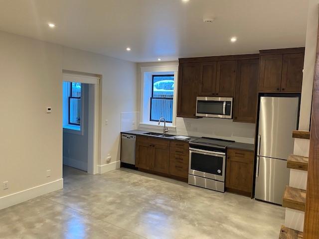 300 E Washington Ave, Breckenridge, CO 80424 - kitchen featuring stainless steel appliances, finished concrete floors, recessed lighting, dark countertops, and dark brown cabinets