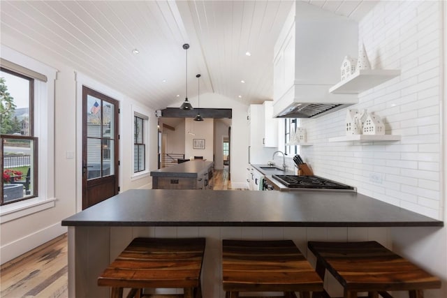 300 E Washington Ave, Breckenridge, CO 80424 - kitchen featuring dark countertops, stainless steel gas stovetop, a peninsula, backsplash, and vaulted ceiling